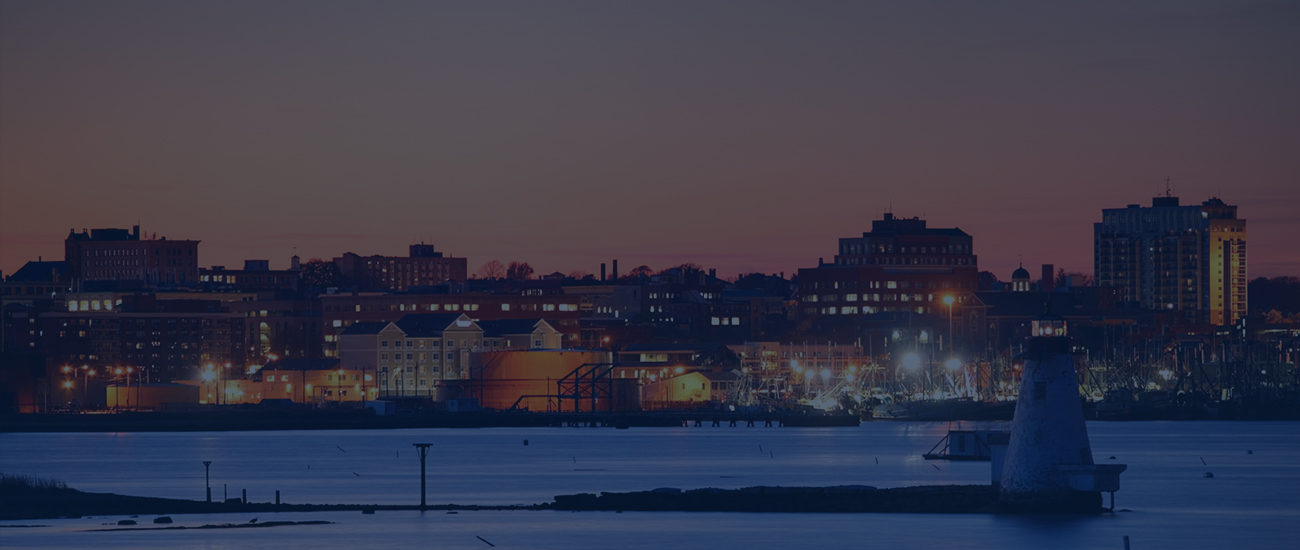 Photograph of a dock and buildings on a coastline.